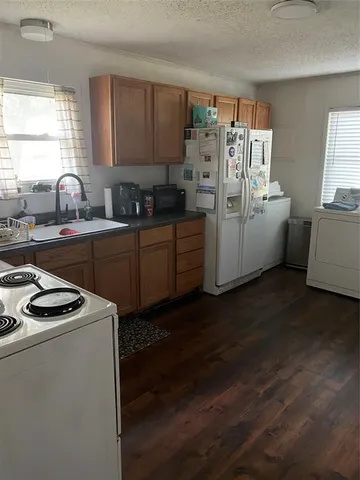 a kitchen with sink a refrigerator and window