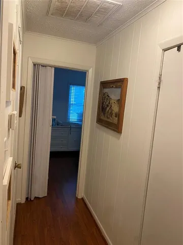 a view of a hallway with wooden floor and closet