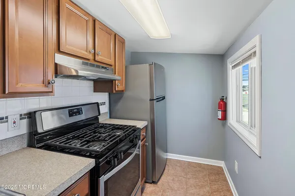 a kitchen with stainless steel appliances granite countertop a refrigerator and a stove top oven
