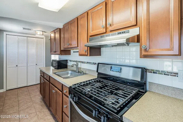 a kitchen with granite countertop a stove sink and cabinets