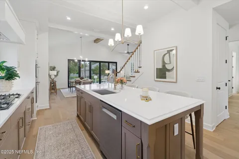 a kitchen with a stove a sink a center island and couches