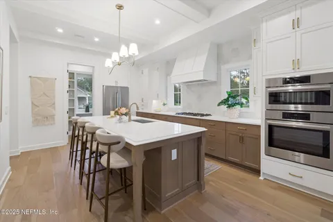 a kitchen with a dining table chairs stainless steel appliances and cabinets
