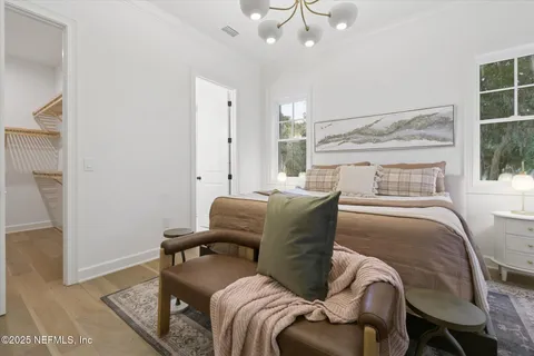 a bedroom with a large bed and a chandelier
