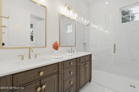 a en suite bathroom with a double vanity sink and a mirror