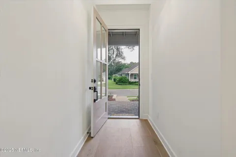 a view of a hallway with a glass door and a window