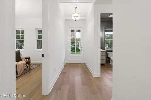 a view of a hallway with windows and chandelier