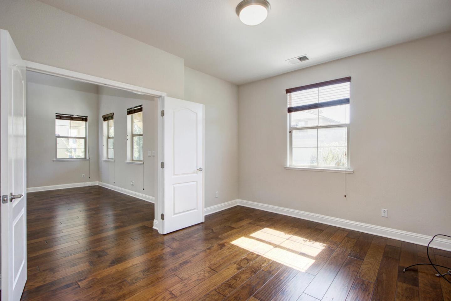9987 Spring View Way Elk Grove, CA 95757 - Photo 11 of 28 an empty room with wooden floor and windows