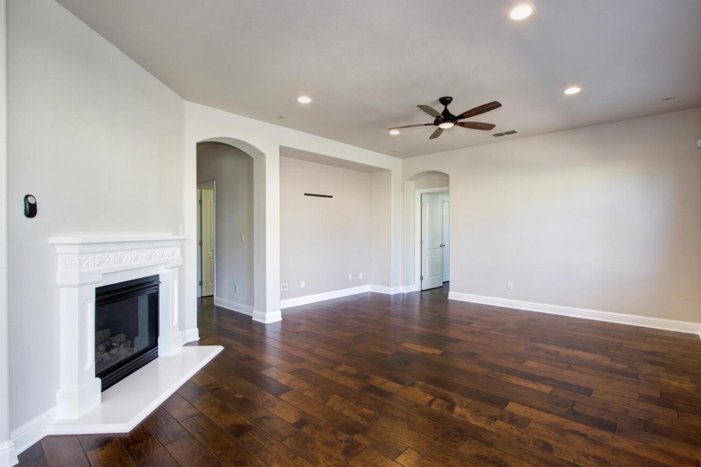 9987 Spring View Way Elk Grove, CA 95757 - Photo 8 of 28 an empty room with wooden floor a fireplace and a window
