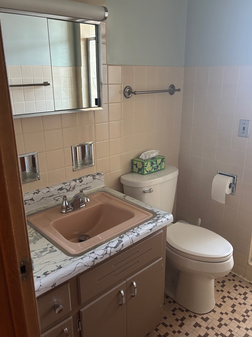 6401 West 52nd Street, Unit 2 Chicago, IL 60638 - Photo 9 of 16 a bathroom with a sink a toilet and mirror