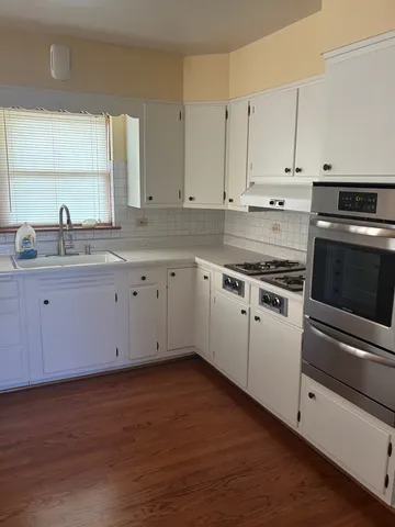 a kitchen with granite countertop white cabinets and white appliances