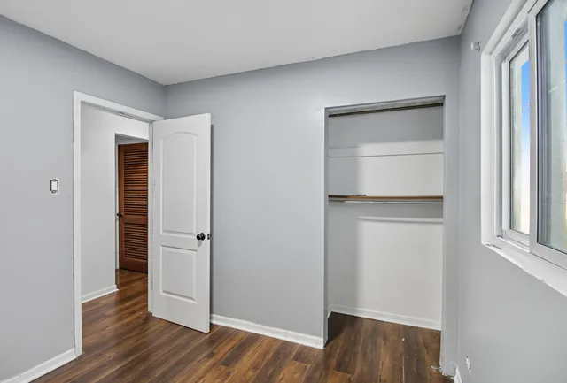 an empty room with wooden floor and closet
