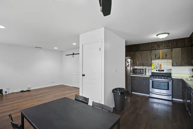 a view of kitchen with refrigerator stove and wooden floor