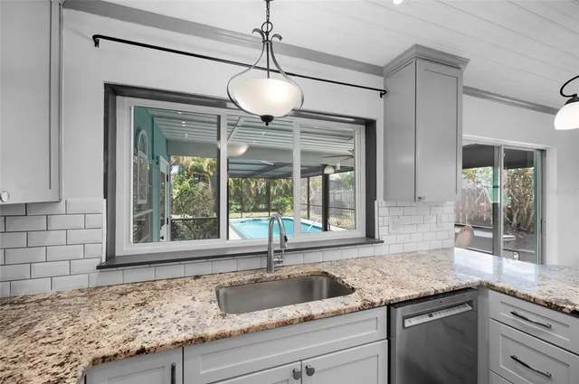 a large kitchen with kitchen island granite countertop a stove sink microwave and refrigerator