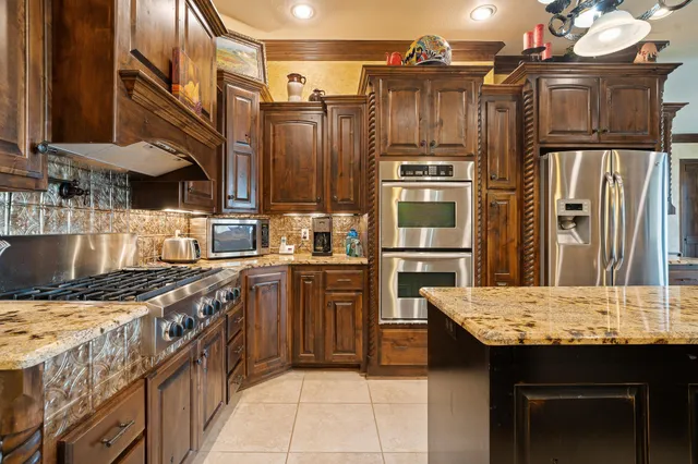 a kitchen with stainless steel appliances granite countertop a stove top oven a sink and dishwasher
