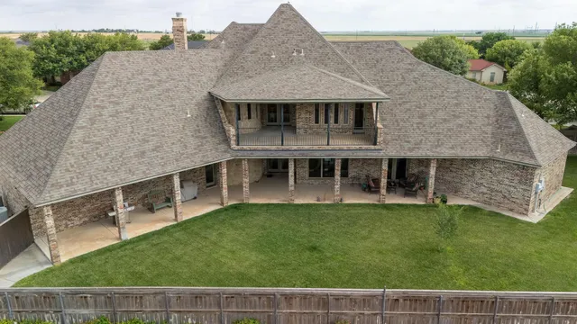 an aerial view of a house with big yard