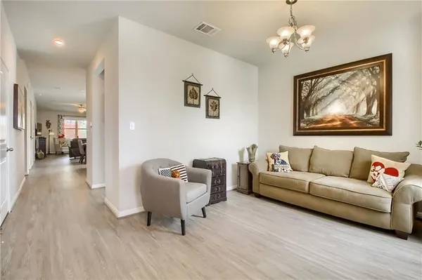 a living room with furniture a wooden floor and a chandelier