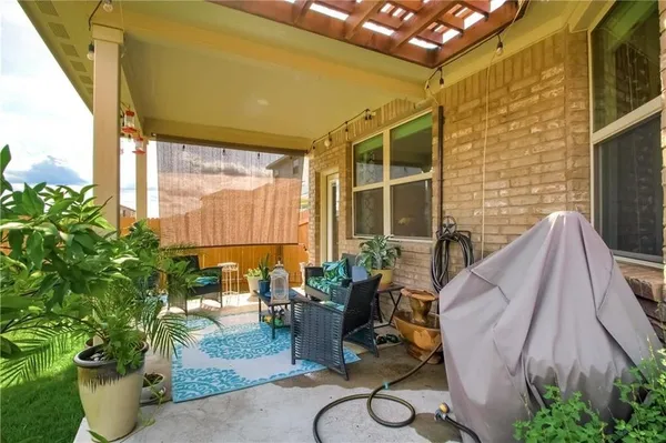 a view of a porch with chairs and potted plants