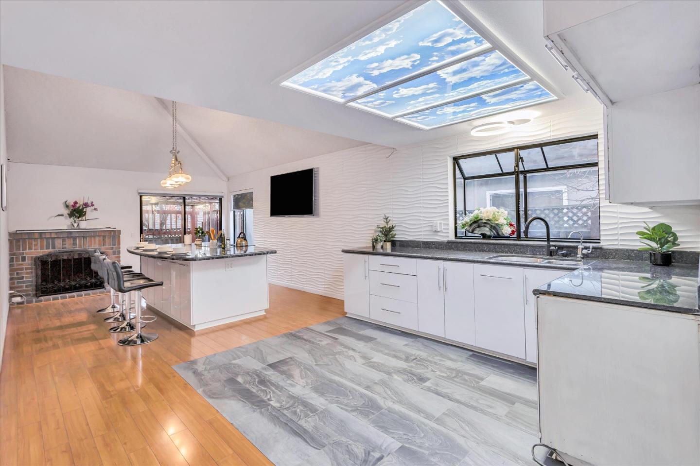 499 Bayview Park Drive Milpitas, CA 95035 - Photo 7 of 41 a kitchen with stainless steel appliances kitchen island granite countertop a sink dishwasher a stove a dining table and chairs with wooden floor