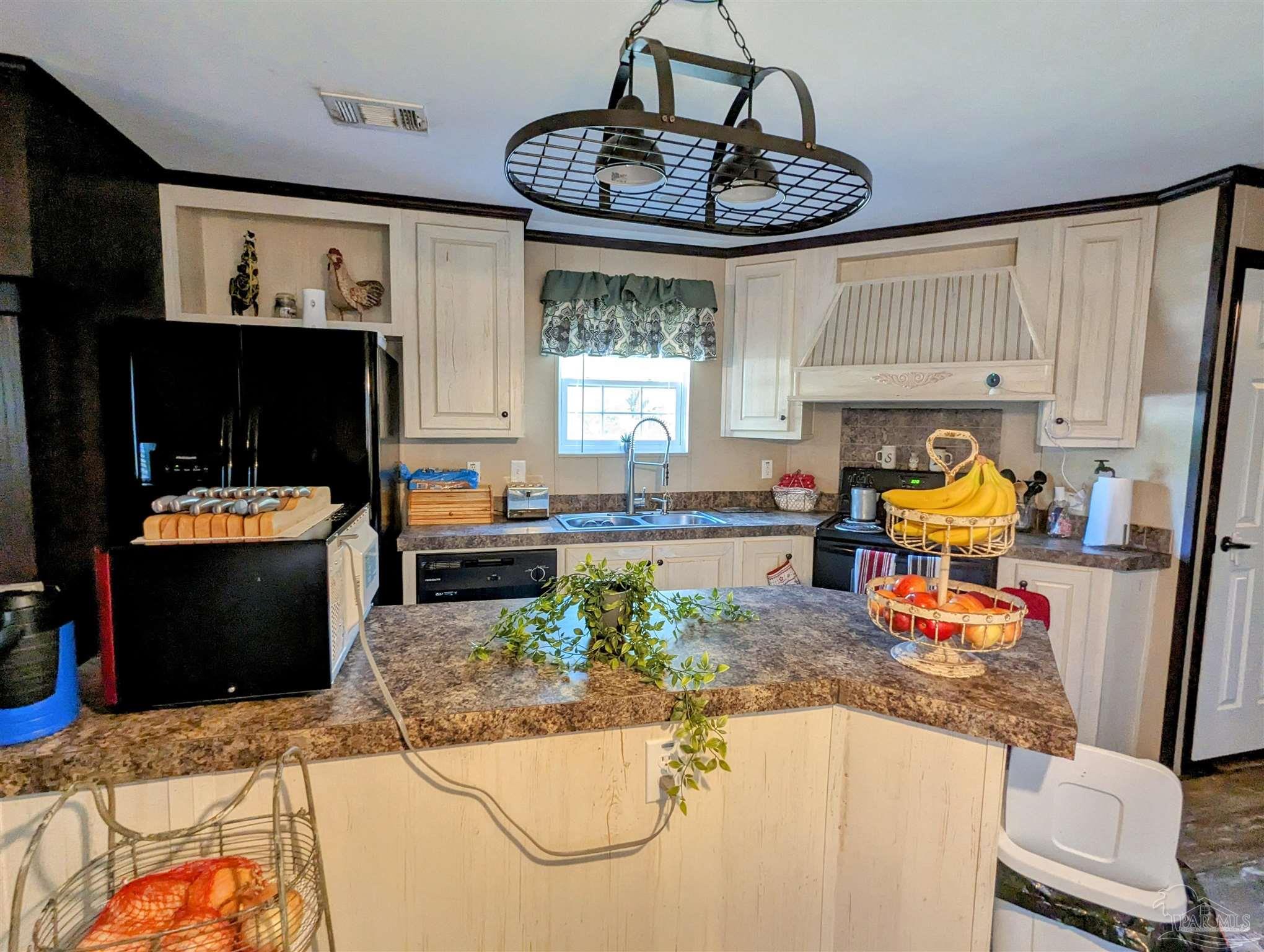 6261 Morgan Road Milton, FL 32570 - Photo 7 of 19 a kitchen with a stove a refrigerator and a sink