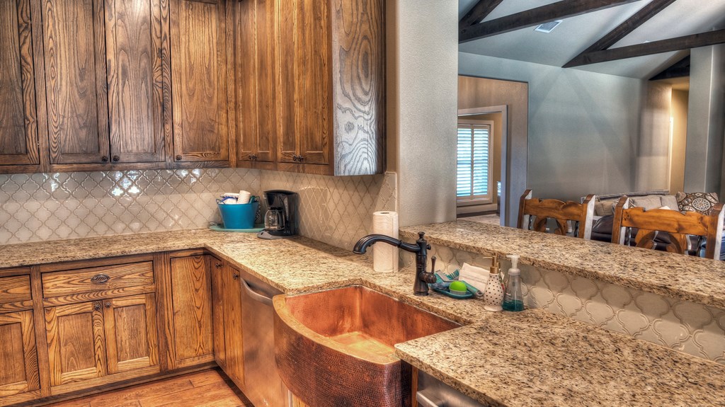 6454 Highway 83 Leakey, TX 78873 - Photo 30 of 74 a kitchen with stainless steel appliances granite countertop a sink a stove and a wooden cabinets