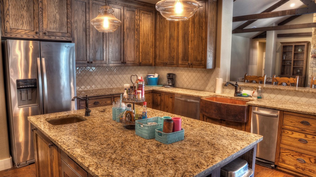 6454 Highway 83 Leakey, TX 78873 - Photo 34 of 74 a kitchen with stainless steel appliances granite countertop a sink a refrigerator and wooden cabinets