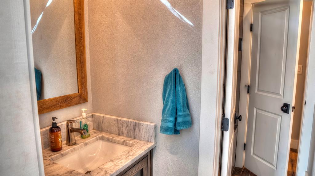6454 Highway 83 Leakey, TX 78873 - Photo 49 of 74 a bathroom with a granite countertop sink and a mirror