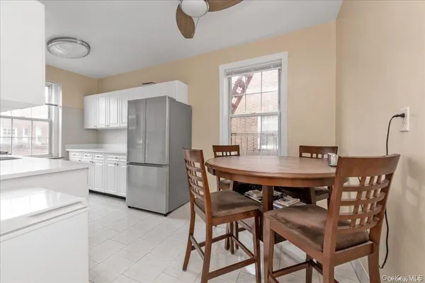 a kitchen with a table chairs refrigerator and cabinets