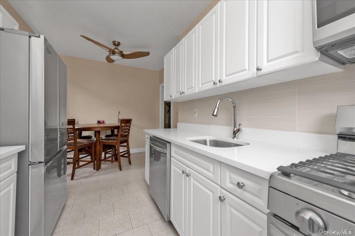 175-06 Devonshire Road, Unit 6O Queens, NY 11432 - Photo 3 of 14 a kitchen with stainless steel appliances granite countertop a sink and cabinets