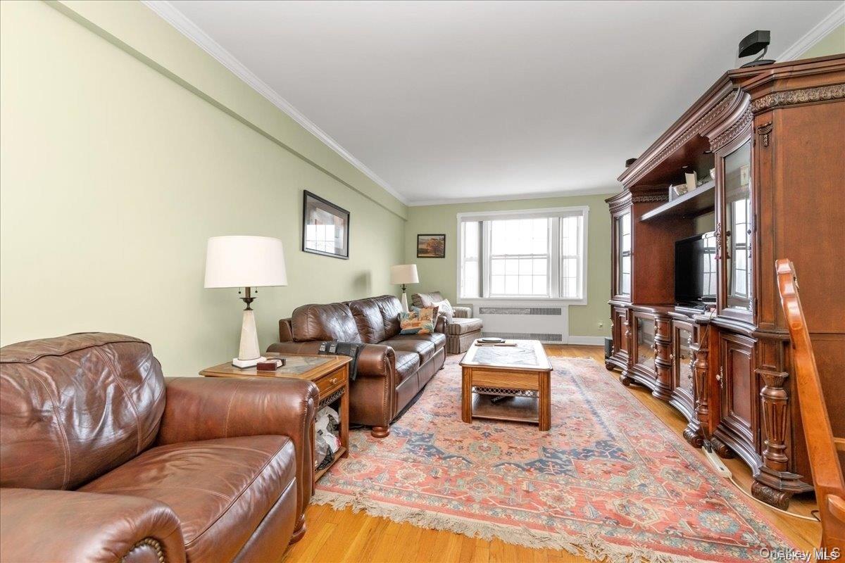 175-06 Devonshire Road, Unit 6O Queens, NY 11432 - Photo 4 of 14 a living room with furniture and a flat screen tv