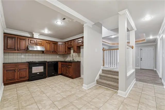 a view of an empty room with wooden floor and a ceiling fan