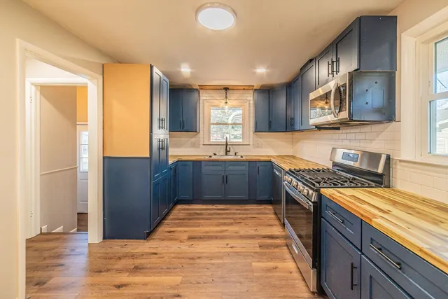 a large kitchen with stainless steel appliances granite countertop a stove a sink and a refrigerator