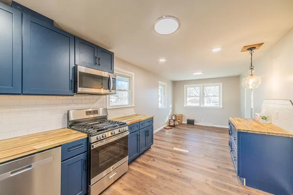 a kitchen with stainless steel appliances wooden cabinets and a stove top oven