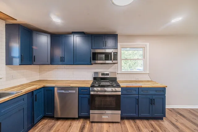 a kitchen with stainless steel appliances granite countertop wooden cabinets and a stove top oven