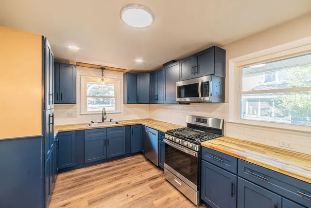 a kitchen with stainless steel appliances granite countertop stove top oven microwave and cabinets