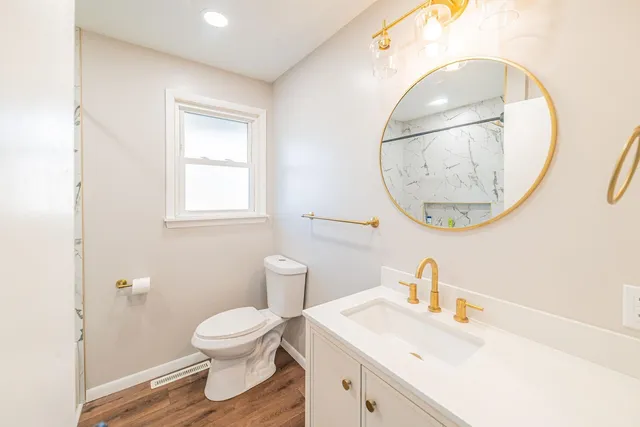 a bathroom with a toilet a sink and a mirror