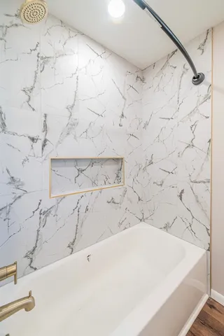 a bathroom with a bathtub and shower