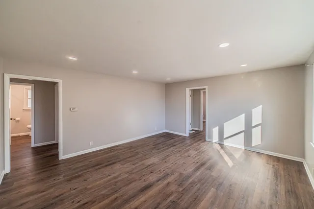 a view of empty room with wooden floor and window