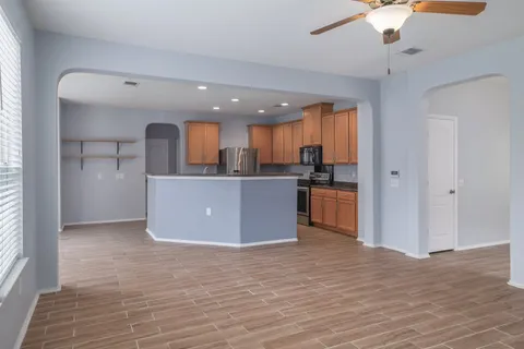 a kitchen with granite countertop a sink a counter top space appliances and cabinets