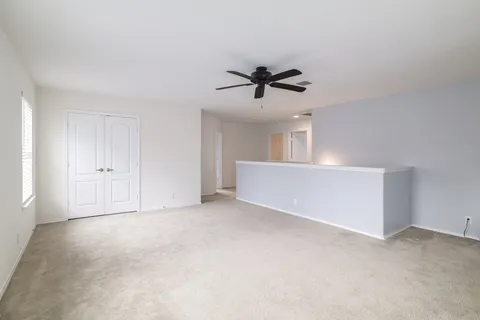 a view of a room with a ceiling fan and a window