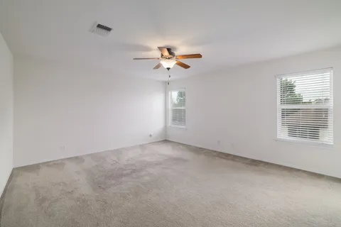 a view of a room with a ceiling fan and a window