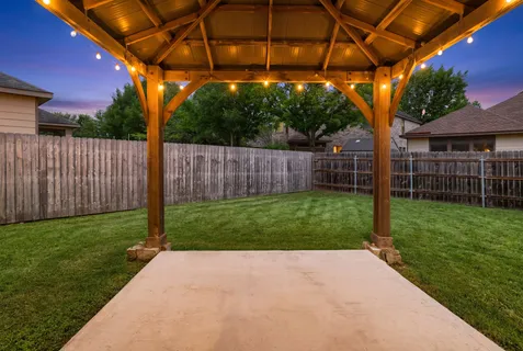 a view of a backyard with wooden fence