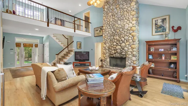 a living room with furniture and a dining table with wooden floor