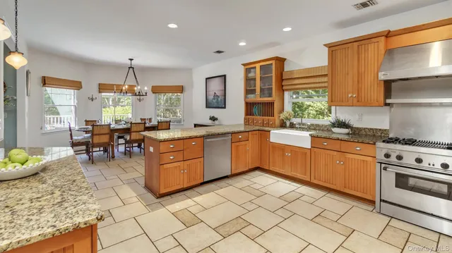a kitchen with stainless steel appliances granite countertop a stove a sink a microwave and a refrigerator