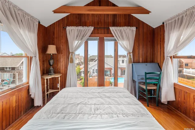 a bedroom with furniture and a large window