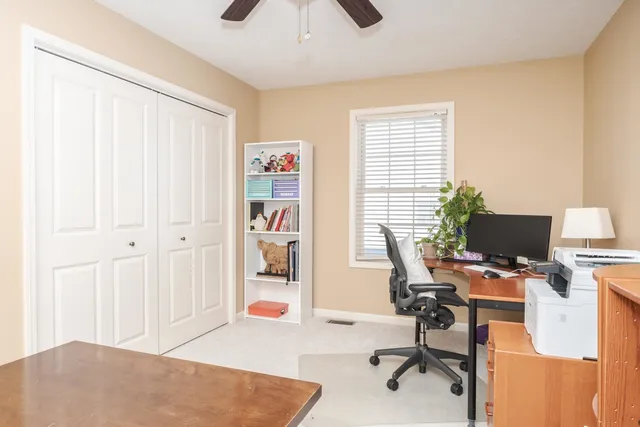 a view of a workspace with furniture and a window