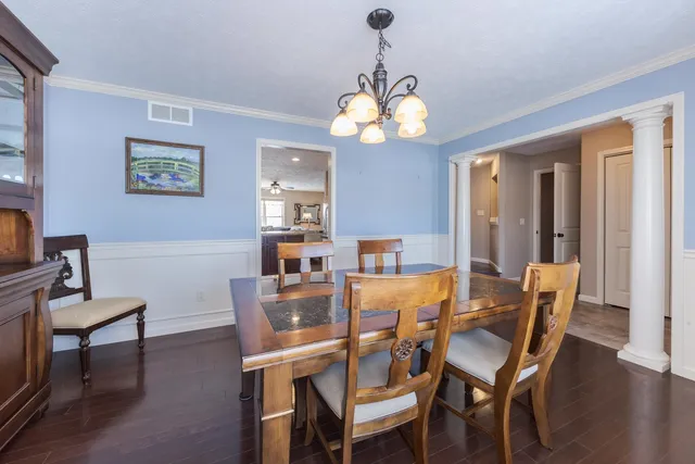 a view of a dining room with furniture wooden floor and a chandelier