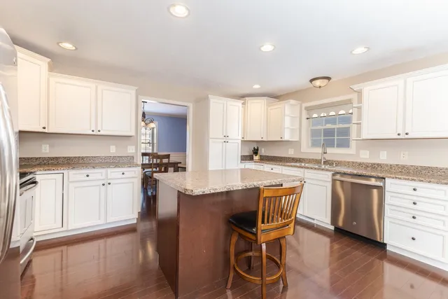a kitchen with granite countertop white cabinets and white appliances