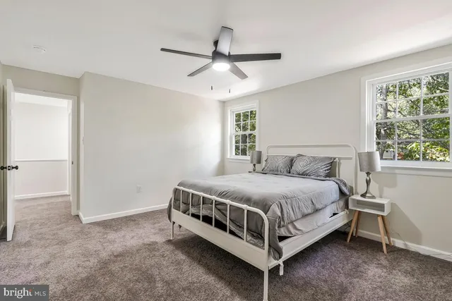 a bed sitting in a spacious bedroom next to a window