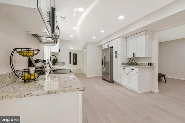 a kitchen with stainless steel appliances granite countertop a sink a stove and a wooden floors