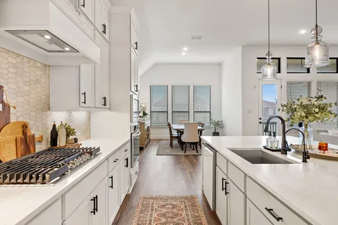 a kitchen with sink stove and cabinets